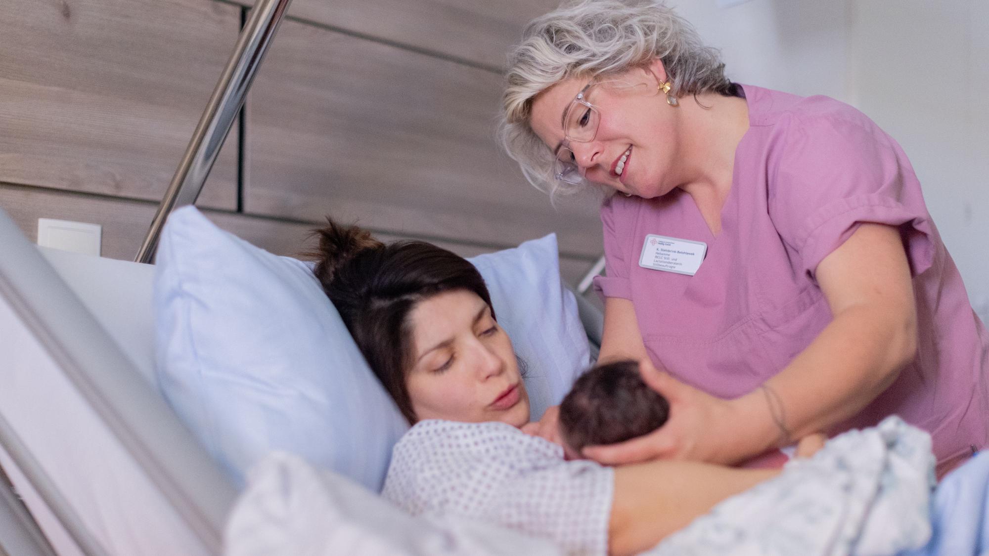 Katharina Steinbrink-Belohlawek hilft Adelina beim Anlegen von Rocco, der in der Nacht im Heilig Geist Krankenhaus per Kaiserschnitt zur Welt kam.