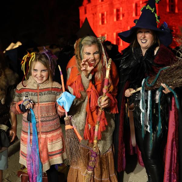 Das Bild zeigt eine Besuchergruppe vor der Burg Satzvey. Die Frauen und Mädchen sind als Hexen verkleidet.