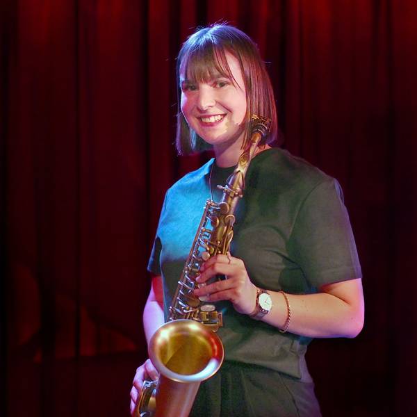 Paul Steimer trägt ein grünes Oberteil und hält ihr Saxofon.