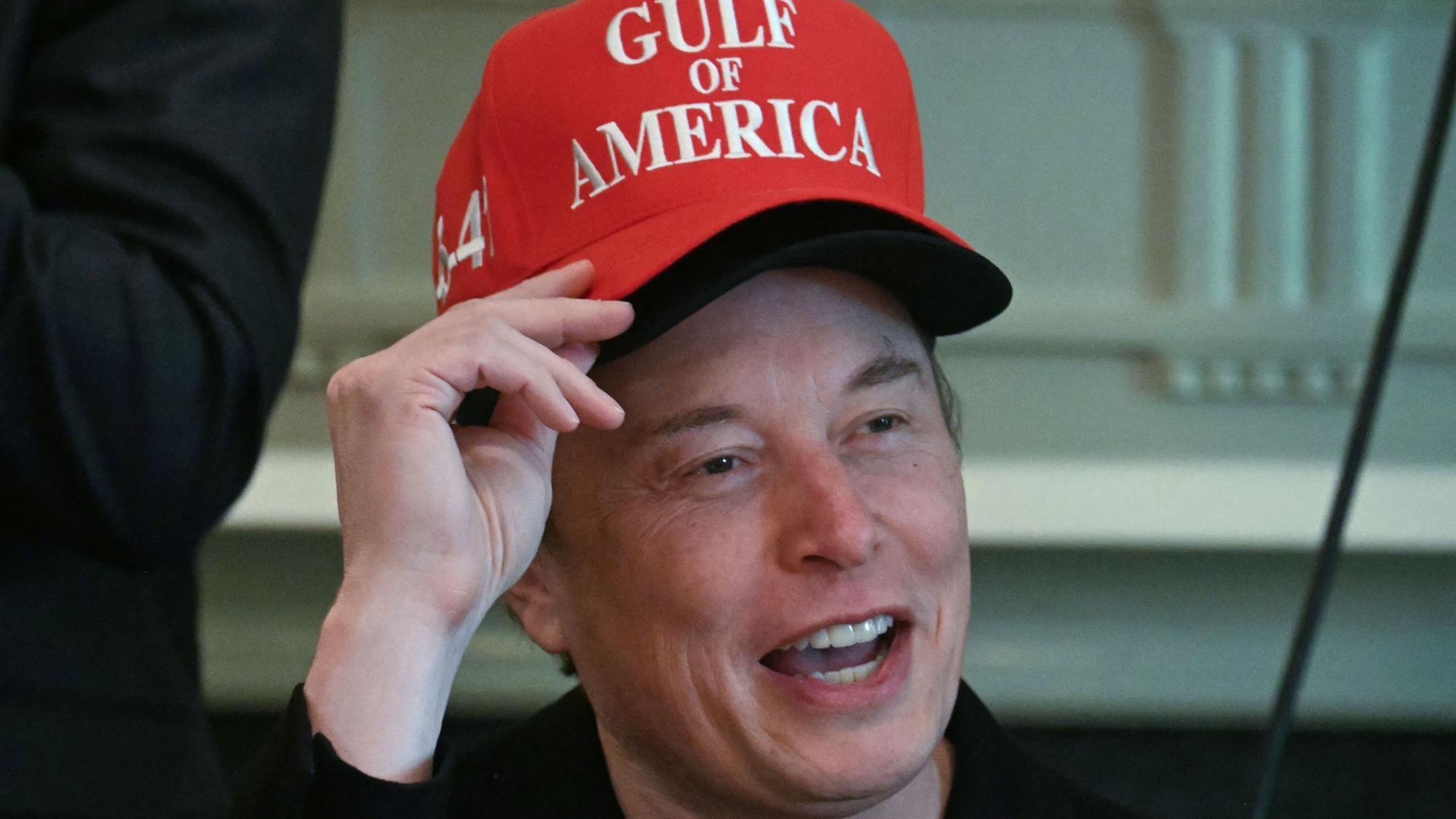 Elon Musk, wearing two hats, speaks during a cabinet meeting in the Cabinet Room of the White House in Washington, DC, on April 30, 2025. (Photo by Jim WATSON / AFP)