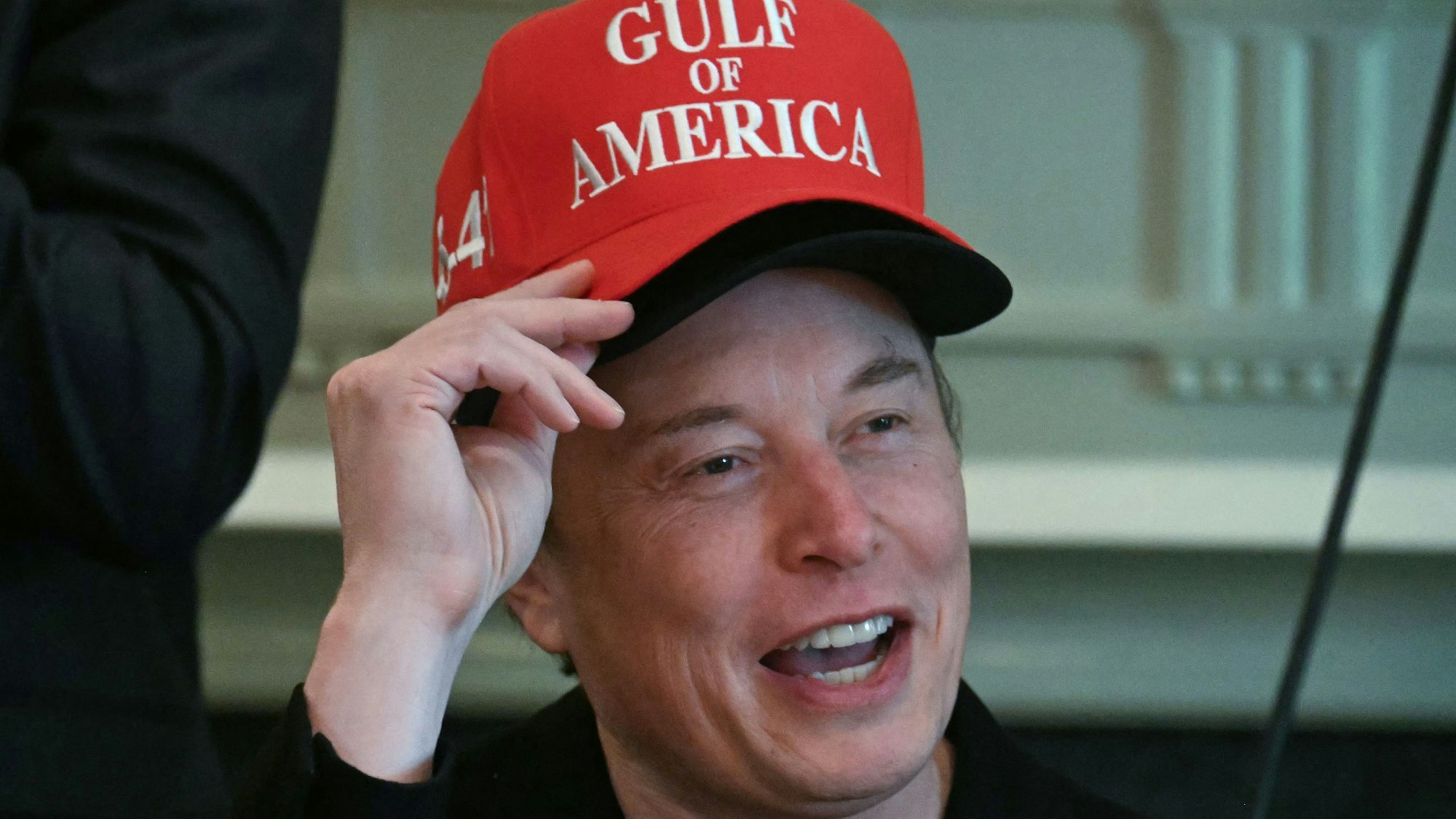 Elon Musk, wearing two hats, speaks during a cabinet meeting in the Cabinet Room of the White House in Washington, DC, on April 30, 2025. (Photo by Jim WATSON / AFP)