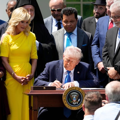 US-Präsident Donald Trump unterzeichnet, umgeben von religiösen Würdenträgern, eine Durchführungsverordnung auf einer Veranstaltung am National Day of Prayer im Rosengarten des Weißen Hauses.