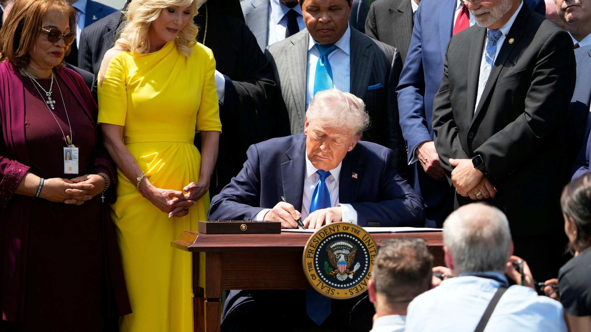 US-Präsident Donald Trump unterzeichnet, umgeben von religiösen Würdenträgern, eine Durchführungsverordnung auf einer Veranstaltung am National Day of Prayer im Rosengarten des Weißen Hauses.