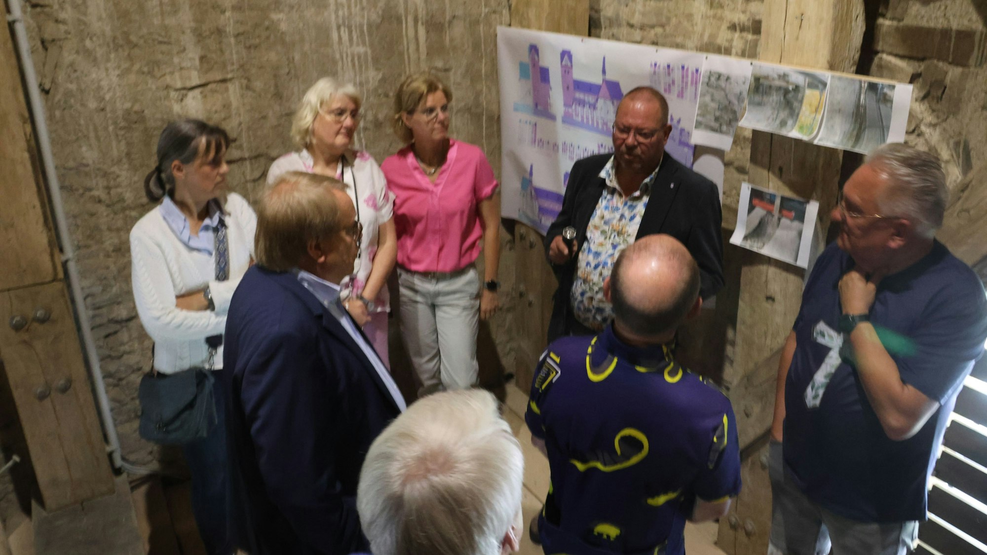 Menschen stehen vor Plänen im Kirchturm.