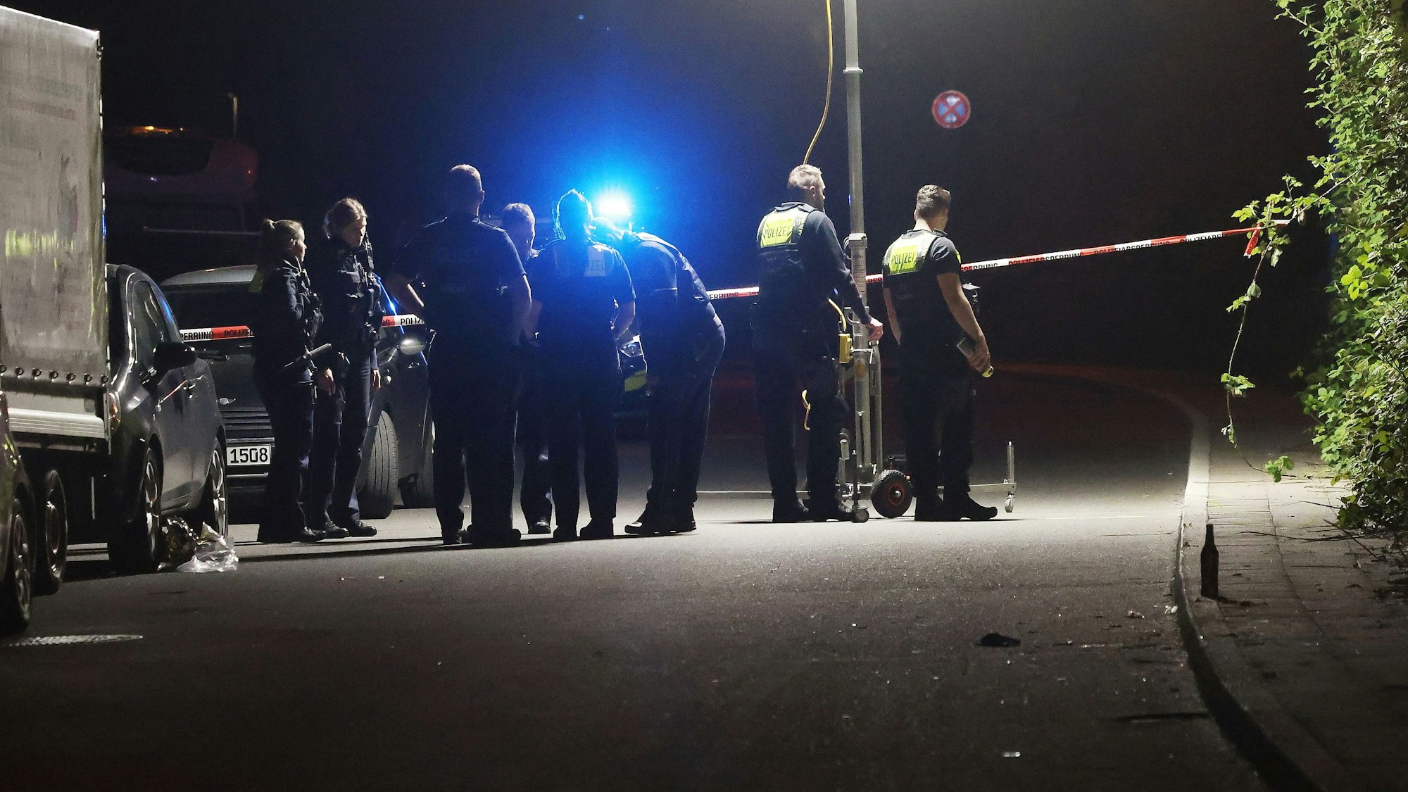 Polizeibeamte des Verkehrsunfall-Aufnahmeteams sichern Spuren nach einem Unfall auf einer Straße in Remscheid-Lennep.