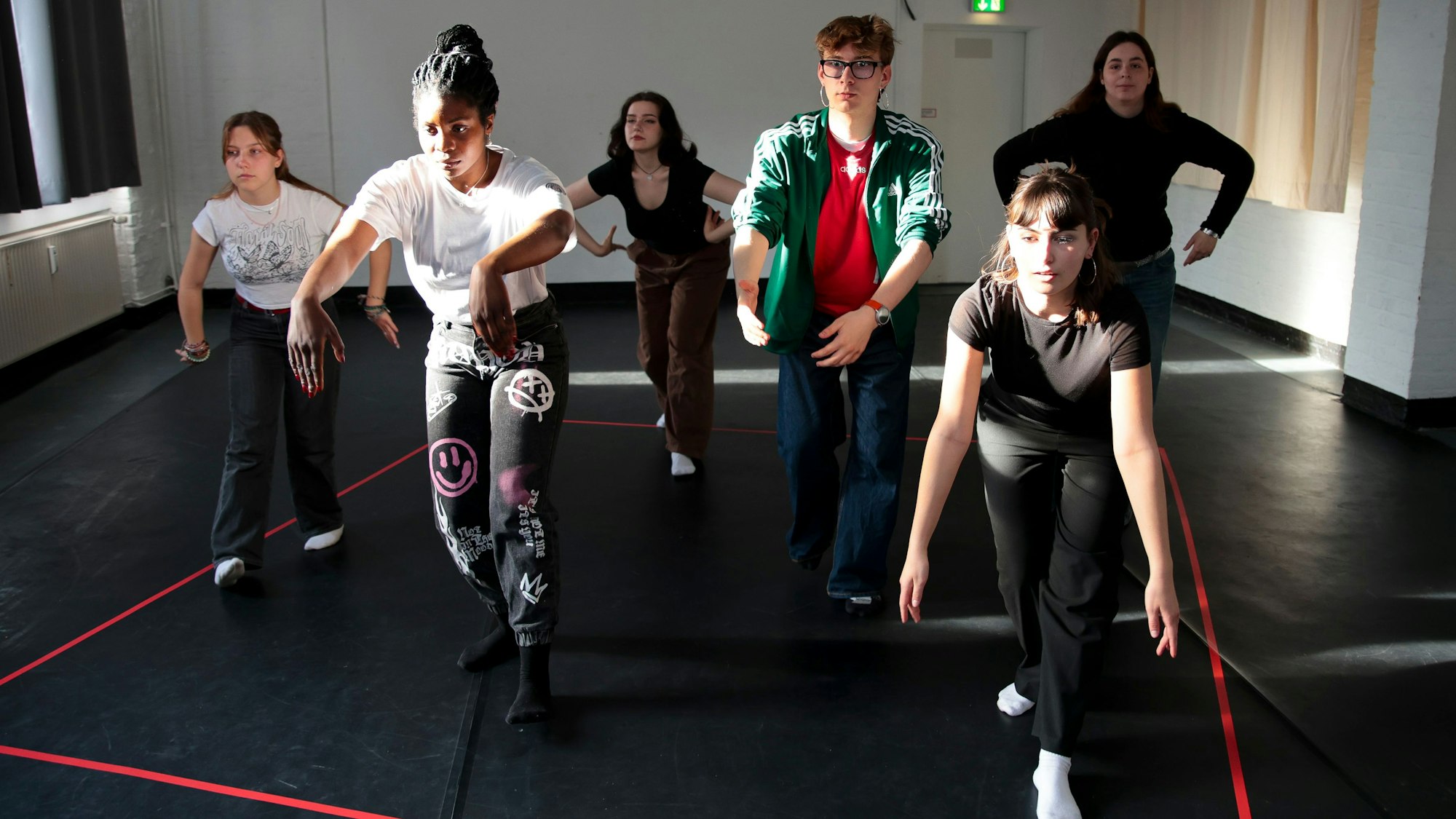 Sechs Jugendliche tanzen und bewegen sich in einem roten Quadrat, es soll die Demokratie symbolisieren.