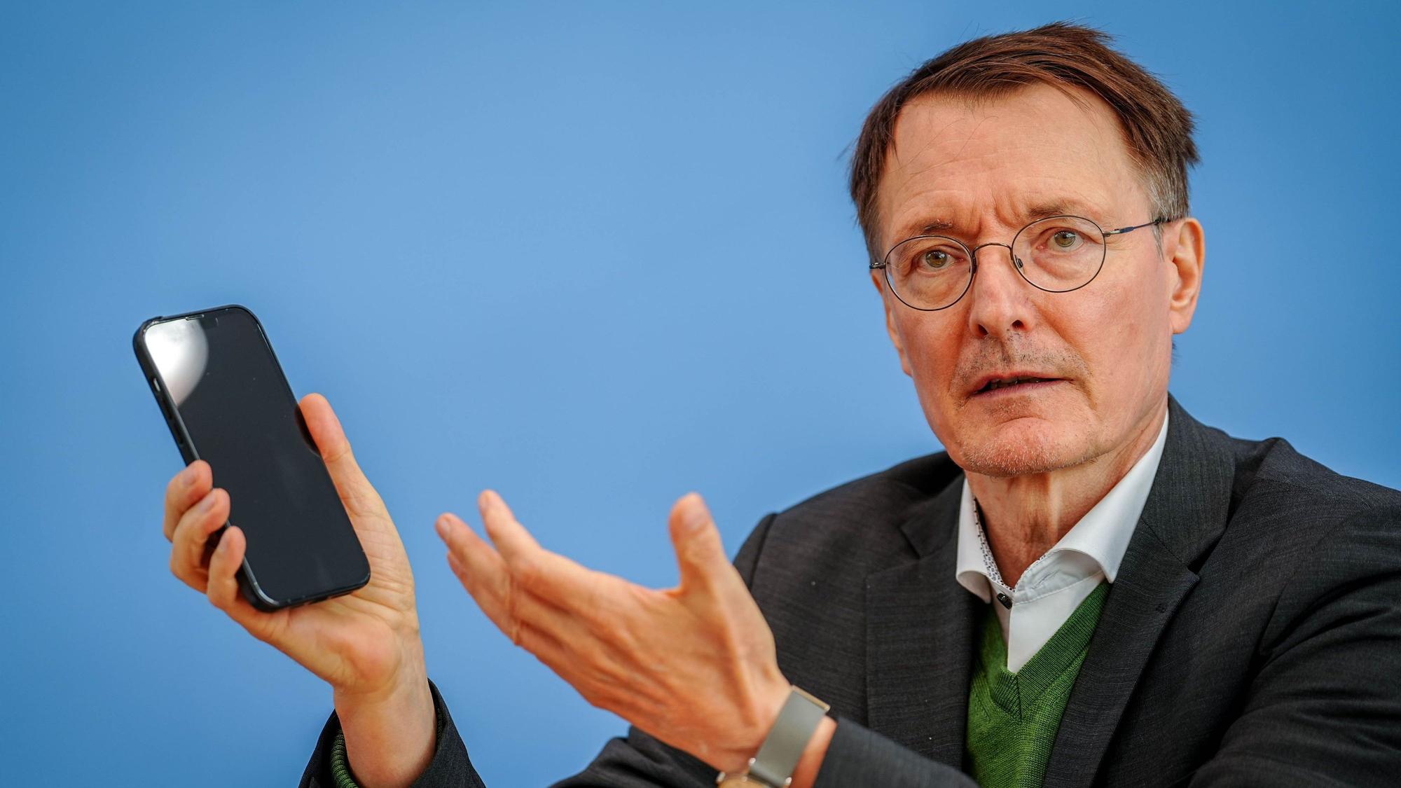 SPD-Politiker Karl Lauterbach mit einem Handy in der Hand. Der Kölner Politiker spricht sich für ein Social-Media-Verbot für Kinder und Jugendliche aus. (Archivbild)