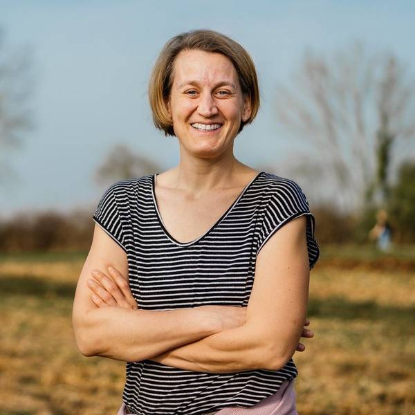 Friederike Hoffmann steht im T-Shirt draußen auf einem Feld.