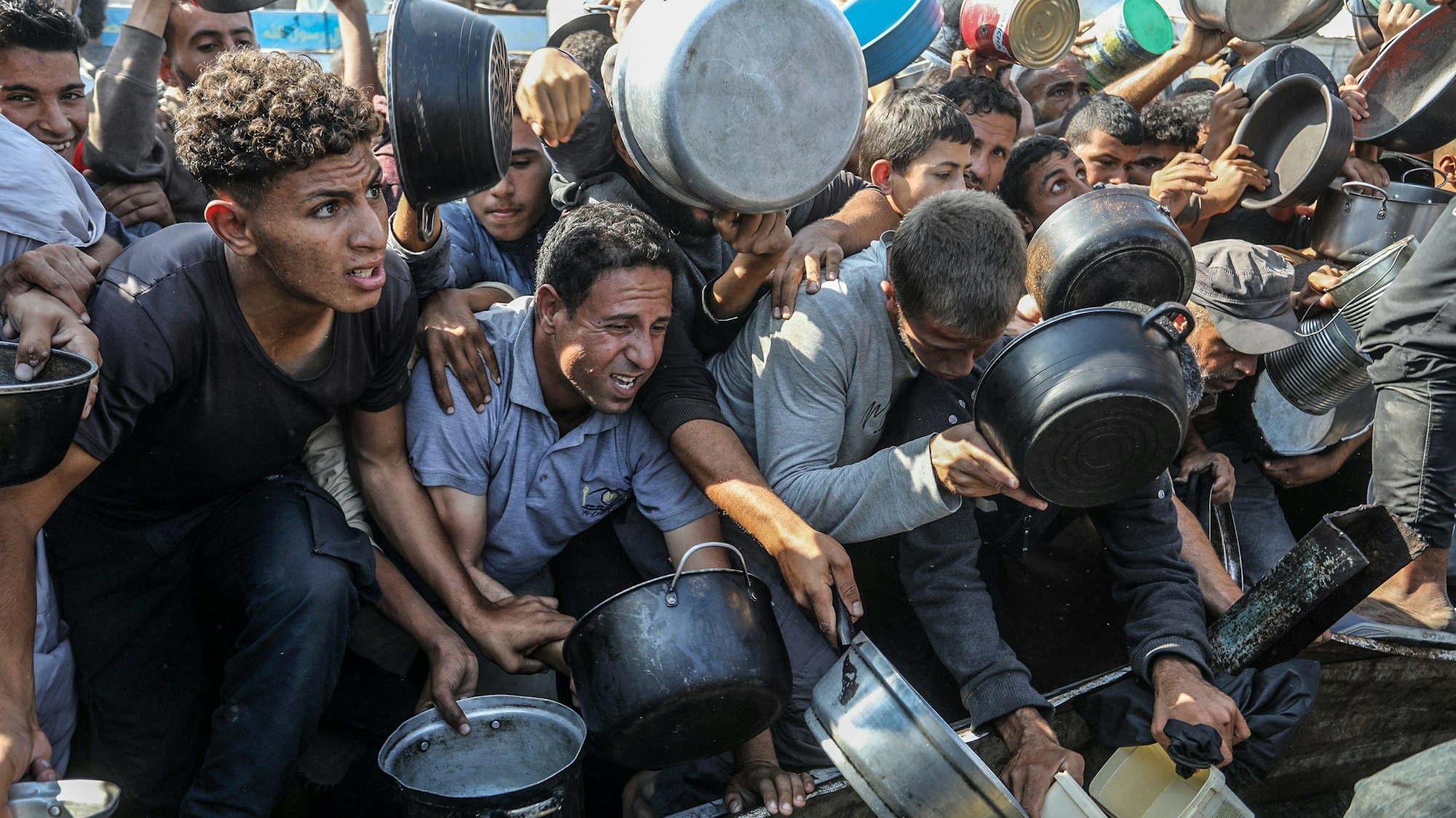 Vertriebene Palästinenser drängeln sich, um Mahlzeiten von der Rafah Charitable Kitchen (Tekia) in Chan Jounis zu erhalten.
