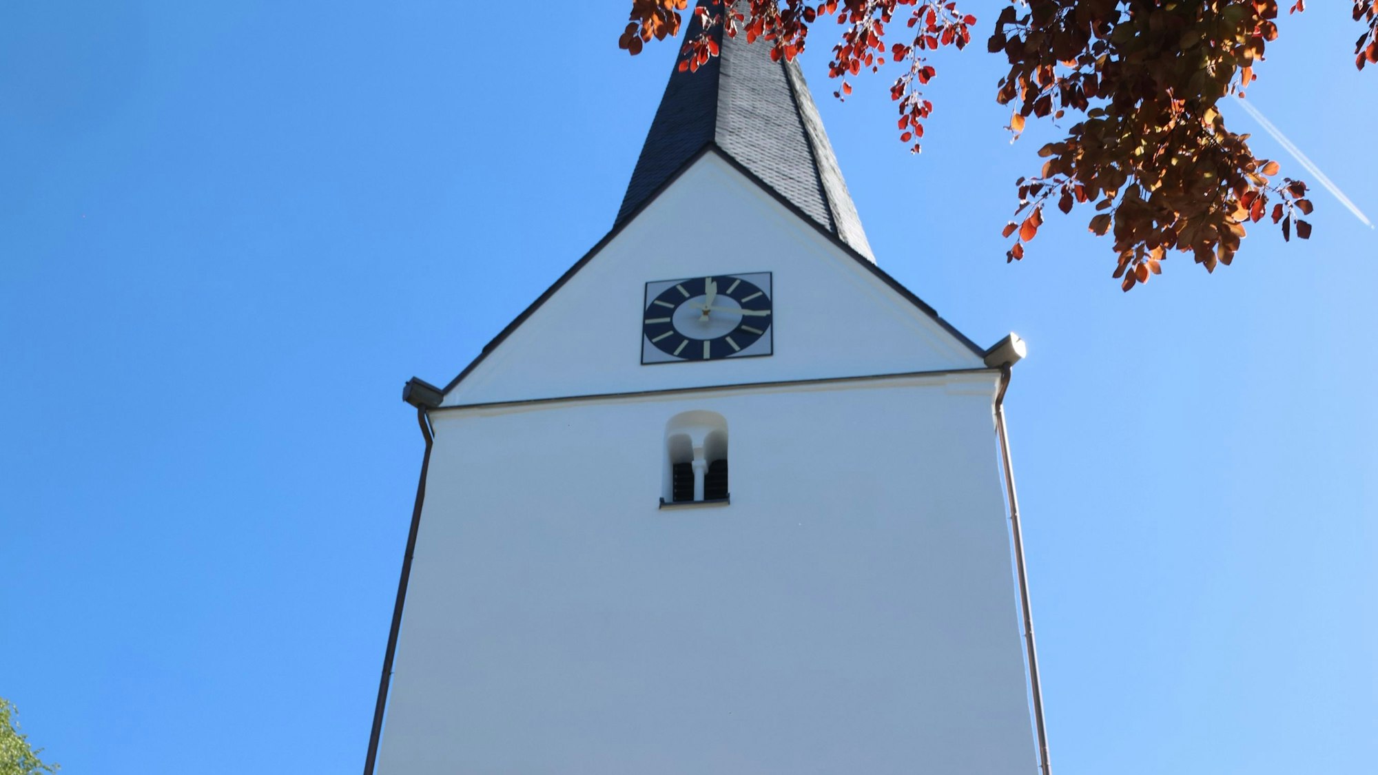 Der Turm der Gummersbacher Kirche vor blauem Himmel.