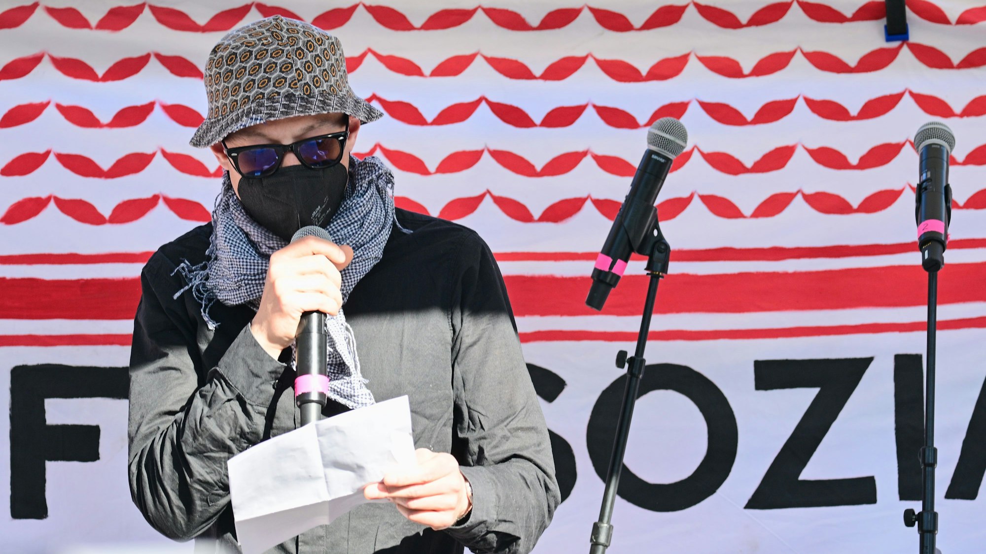 Ein Vermummter liest während der Revolutionären 1. Mai-Demo 2025 ein Grußwort von Daniela Klette vor.