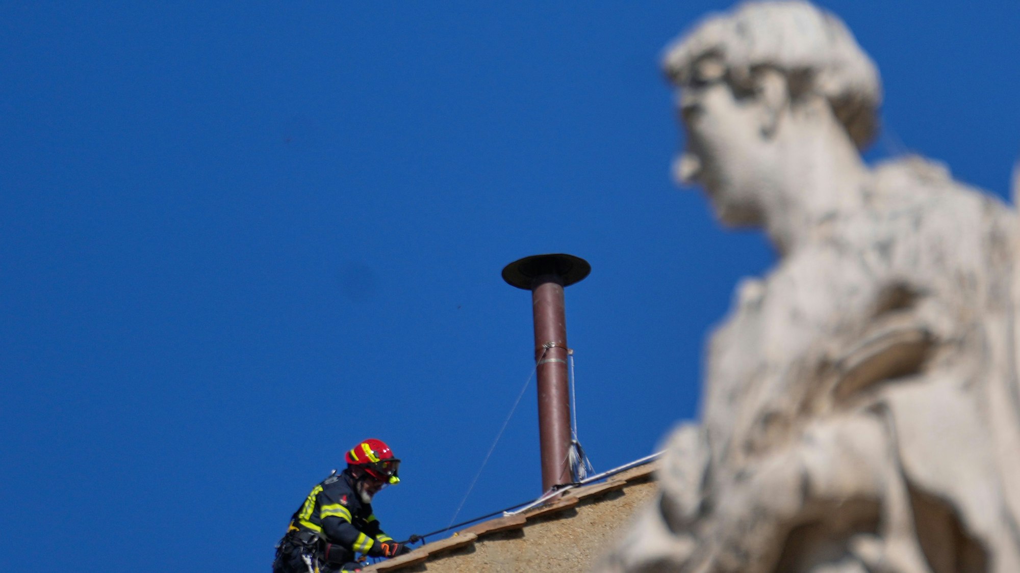 Feuerwehrleute platzieren den Schornstein auf dem Dach der Sixtinischen Kapelle, wo sich die Kardinäle zur Wahl des neuen Papstes versammeln werden.
