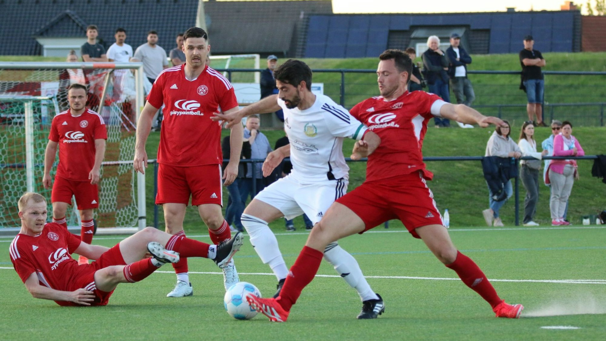 Zülpichs Kapitän Georg Salmon attackiert einen Gegner. Lucas Carell und Alexander Ems schauen stehend, Felix Faure sitzend zu.