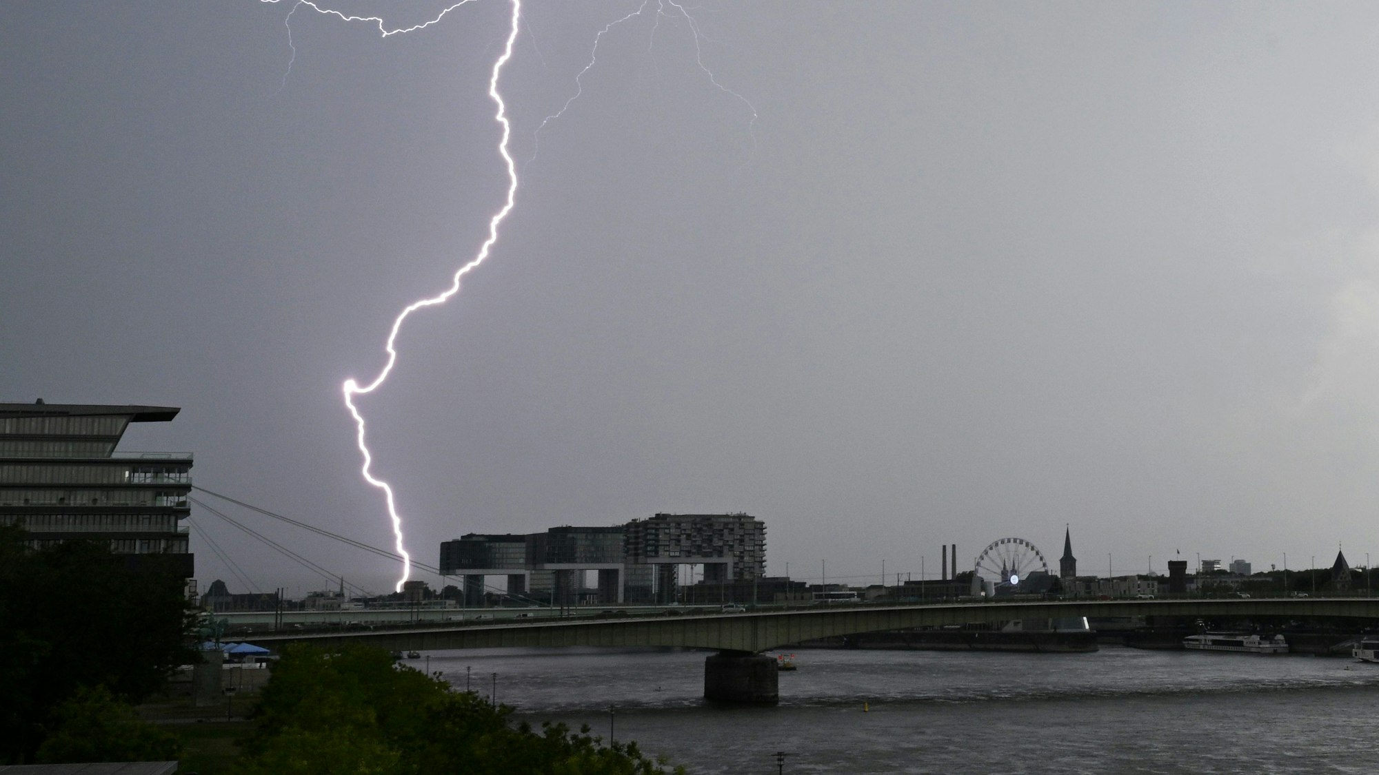 Ein Blitz zuckt bei einem Gewitter über dem Himmel über dem Kölner Süden.