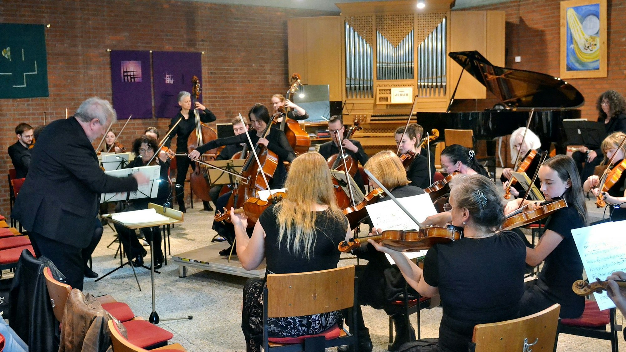 Im Kirchenraum der evangelischen Kirche Weilerswist spielen die Musikerinnen und Musiker des Sinfonischen Orchesters Euskirchen.