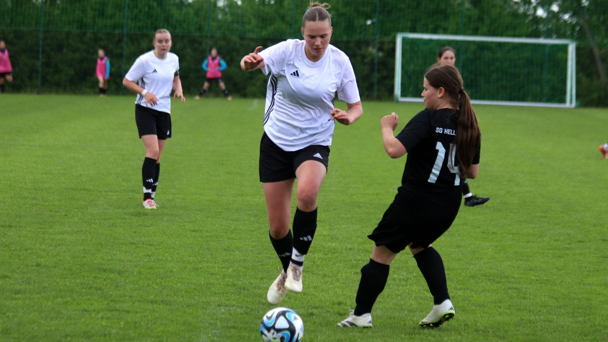 Eine Kommerner Spielerin springt an ihrer Gegenspielerin vorbei.