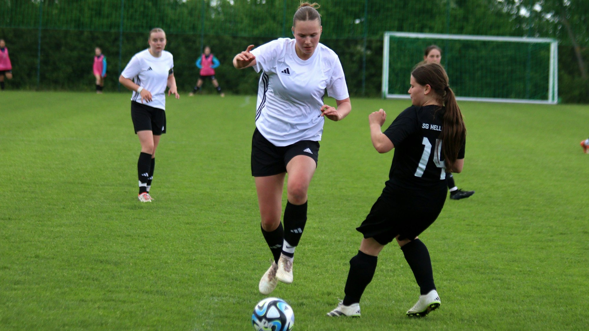Eine Kommerner Spielerin springt an ihrer Gegenspielerin vorbei.