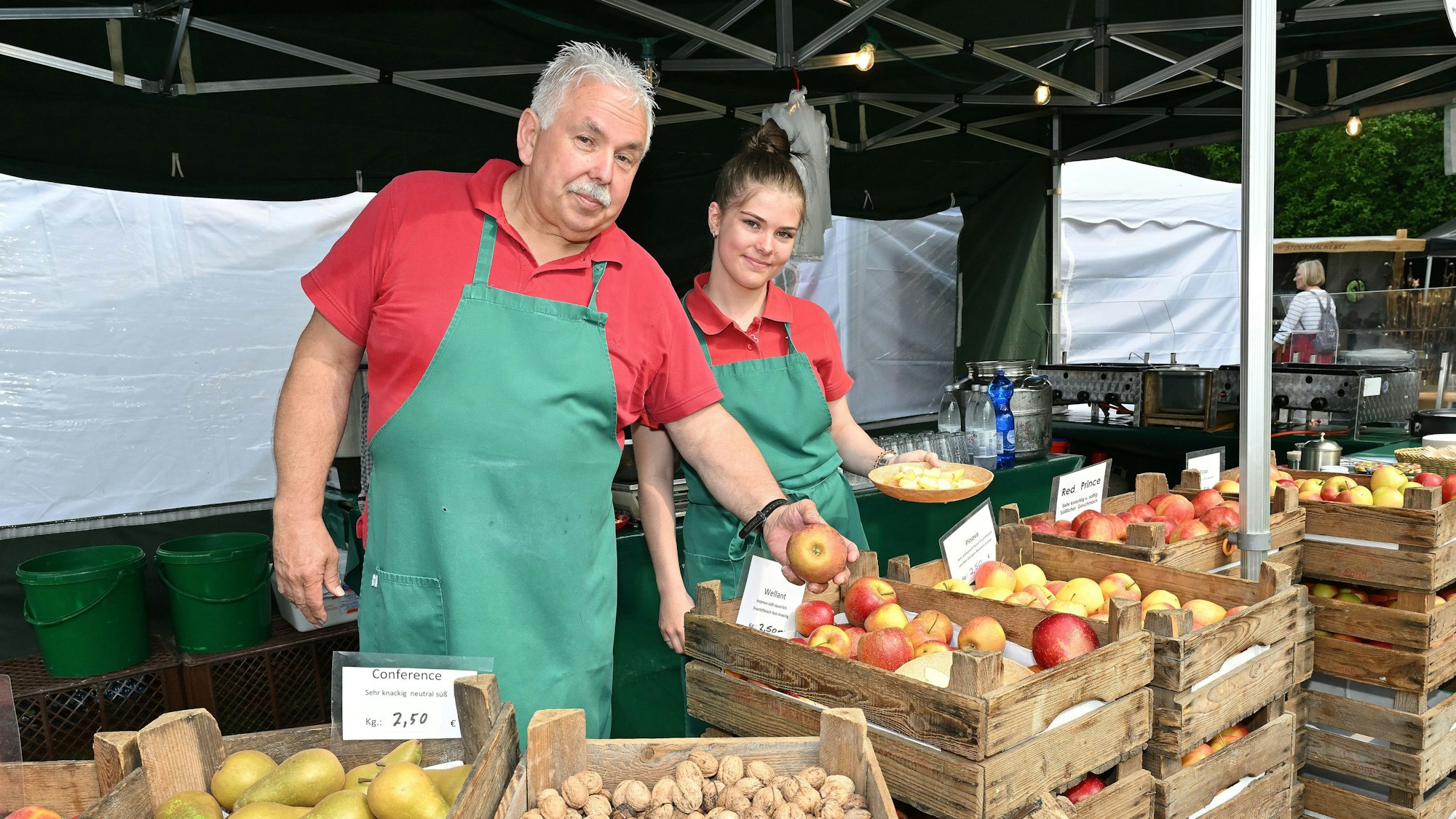 Zwei Händler bieten Birnen, Nüsse und Äpfel an.