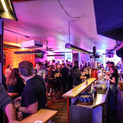 Menschen tanzen und trinken in einer Kneipe.