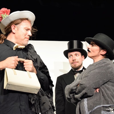 Das Bild zeigt drei Schauspieler bei einer Szene des Theaterstücks „Der Florentiner Hut“.