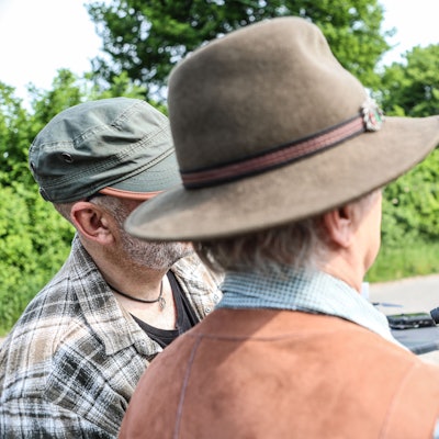 Männer schauen in eine Kamera.