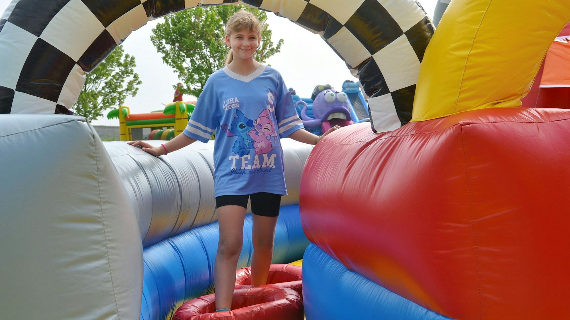 Ein Mädchen steht in einer der aufblasbaren Hüpfburgen.