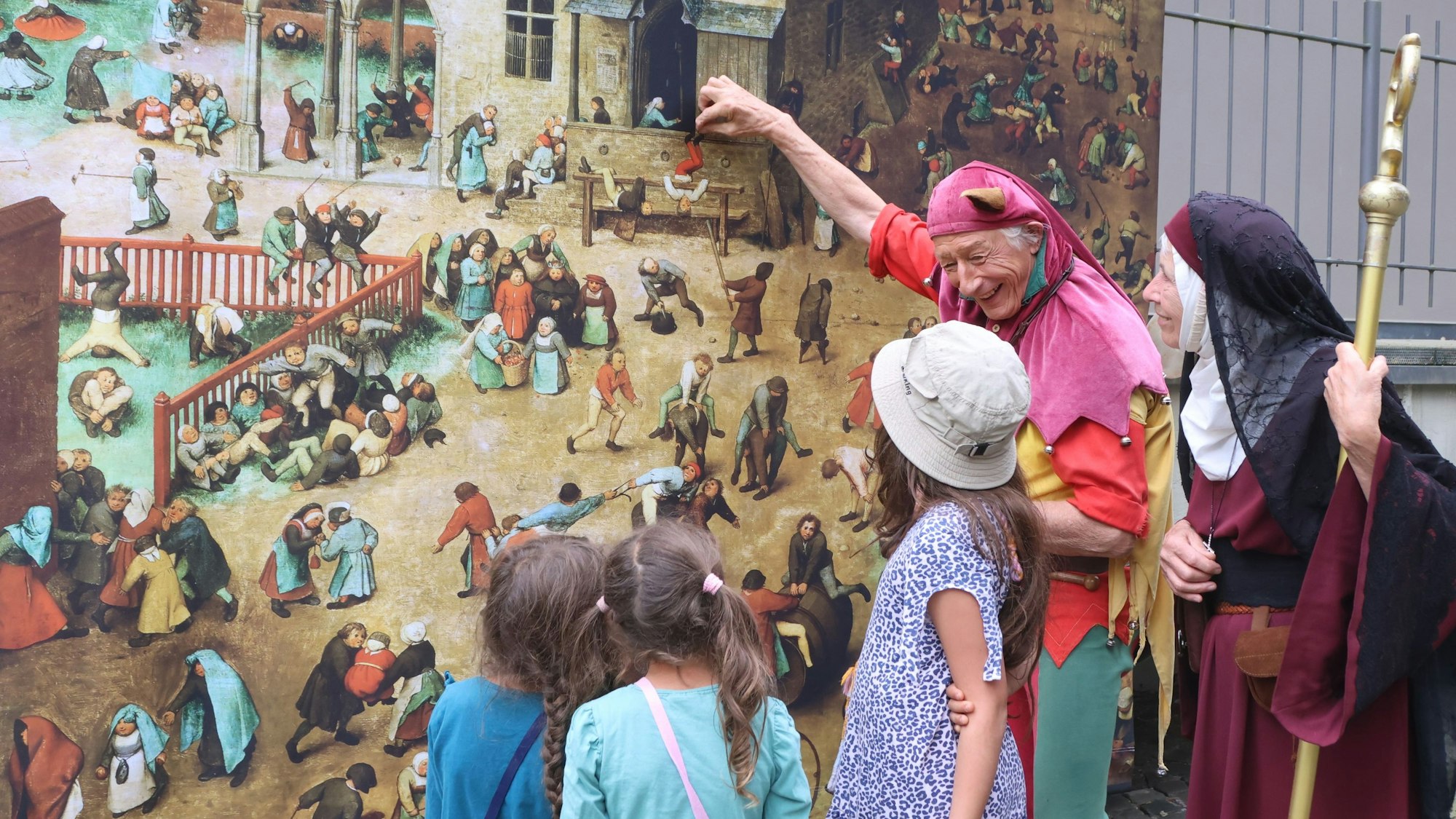 Ein als Narr verkleideter Mann mit Kindern.