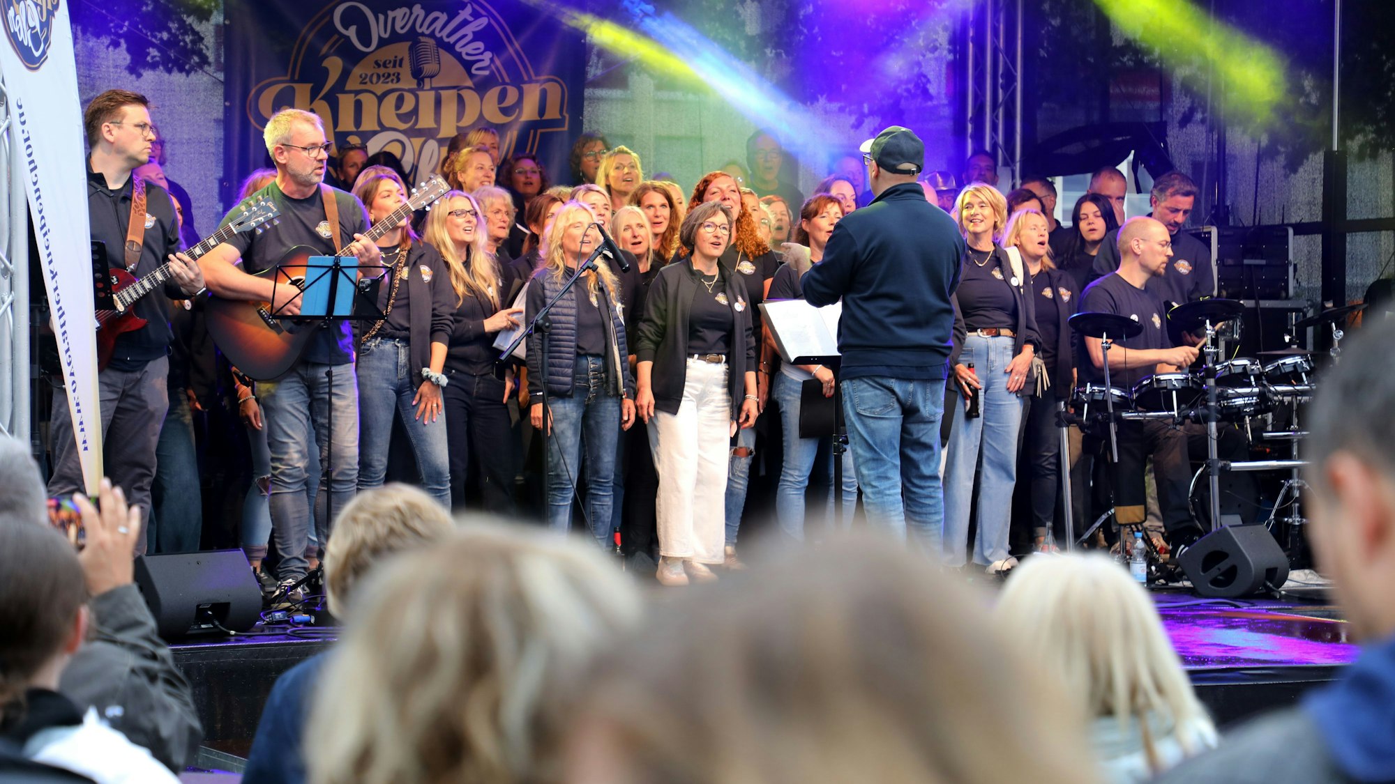 Ein Chor singt auf einer Bühne.