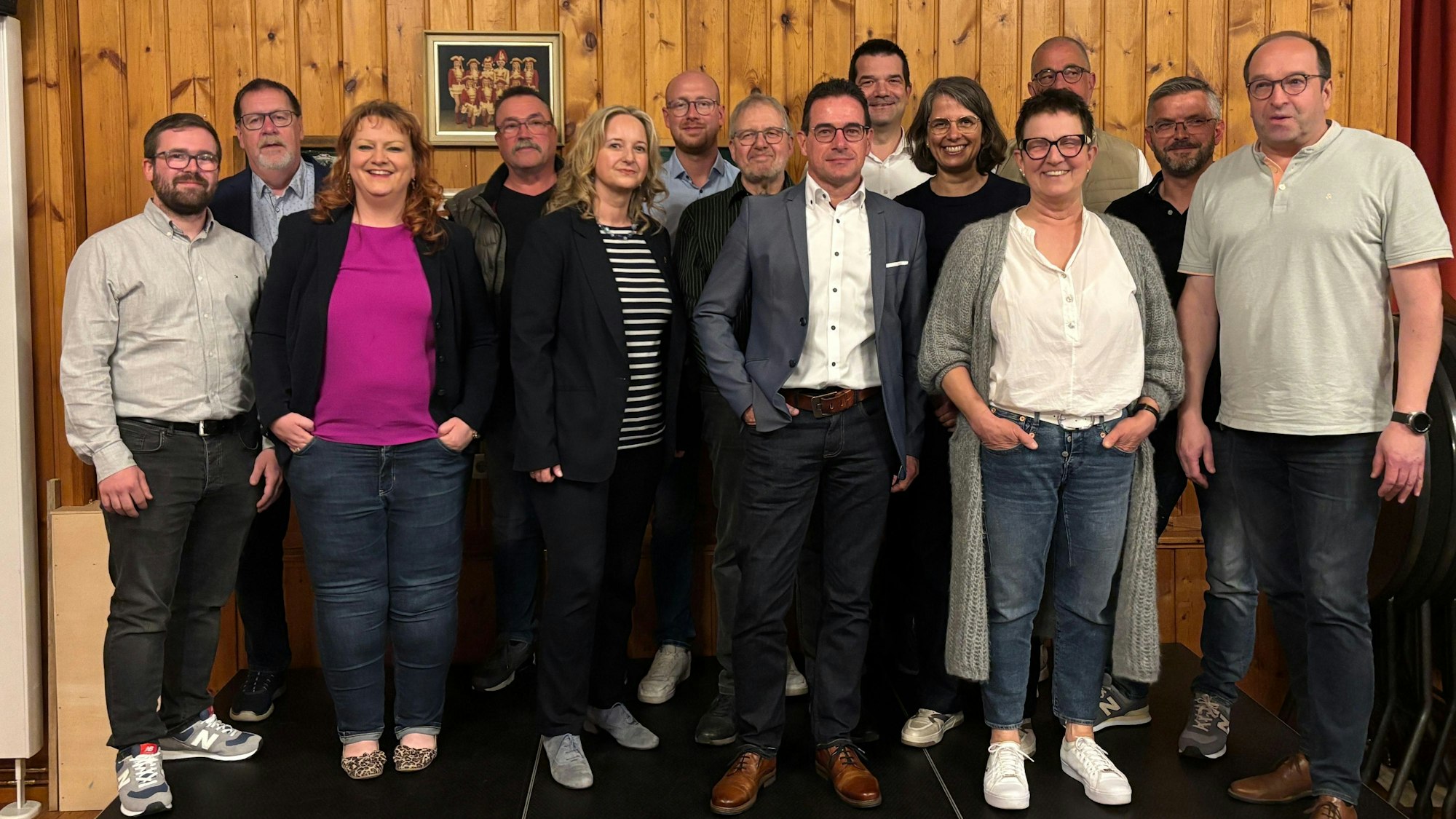 Die Kandidatinnen und Kandidaten der CDU in Kall für die NRW-Kommunalwahl stehen in einem Saal vor einer mit Holz vertäfelten Wand.