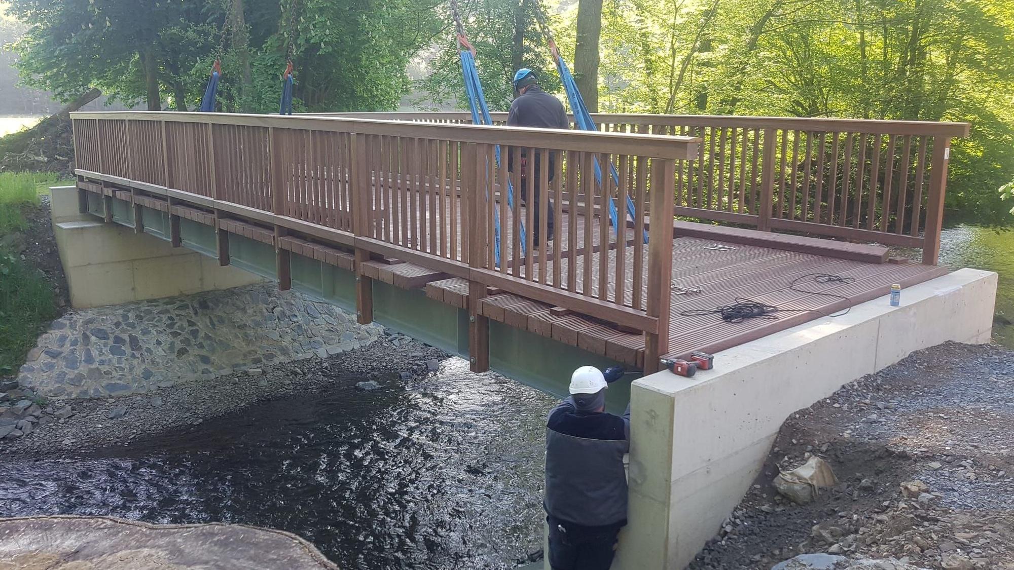 Eine Brücke mit Arbeitern, die sie installieren, ist zu sehen.