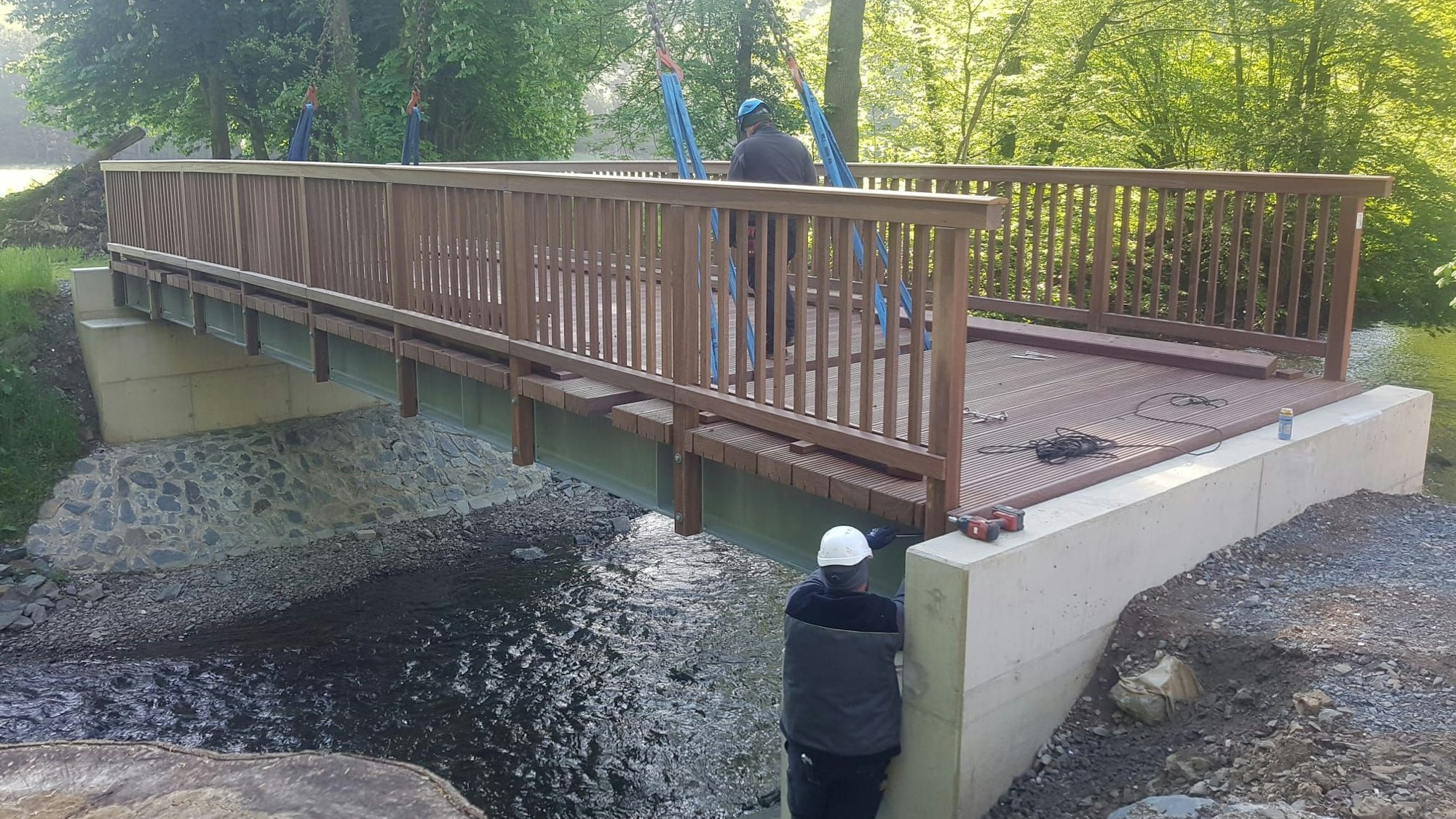 Eine Brücke mit Arbeitern, die sie installieren, ist zu sehen.