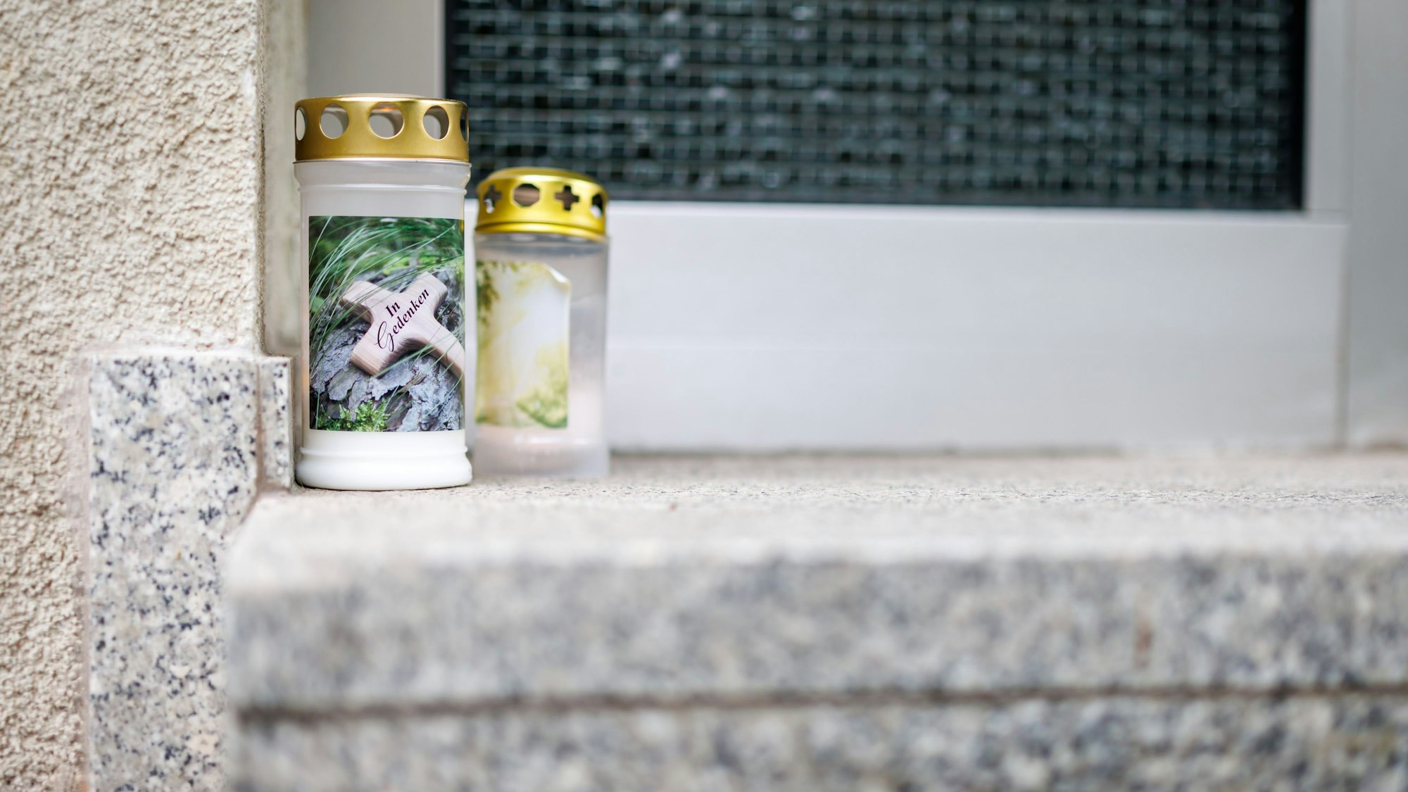 05.05.2025, Nürnberg: Grablichter mit der Aufschrift «In Gedenken» stehen an einem Hauseingang in der Nürnberger Südstadt. Vergangenen Mittwoch (05.05.2025) fand die Polizei in einer Wohnung des Wohnhauses einen toten 19-Jährigen und eine lebensgefährlich verletzte 14-Jährige. Ein 15-Jähriger sitzt wegen des Verdachts des Mordes an dem 19-Jährigen in Untersuchungshaft. Foto: Daniel Karmann/dpa +++ dpa-Bildfunk +++