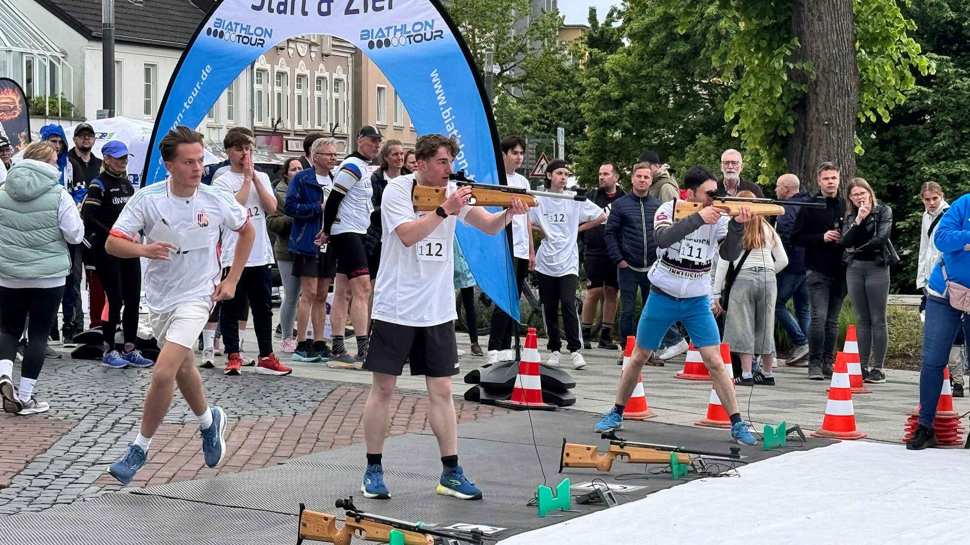 Zwei der drei Disziplinen des Bergheimer Citybiathlon sind auf einem Bild zu sehen: Laufen und schießen.