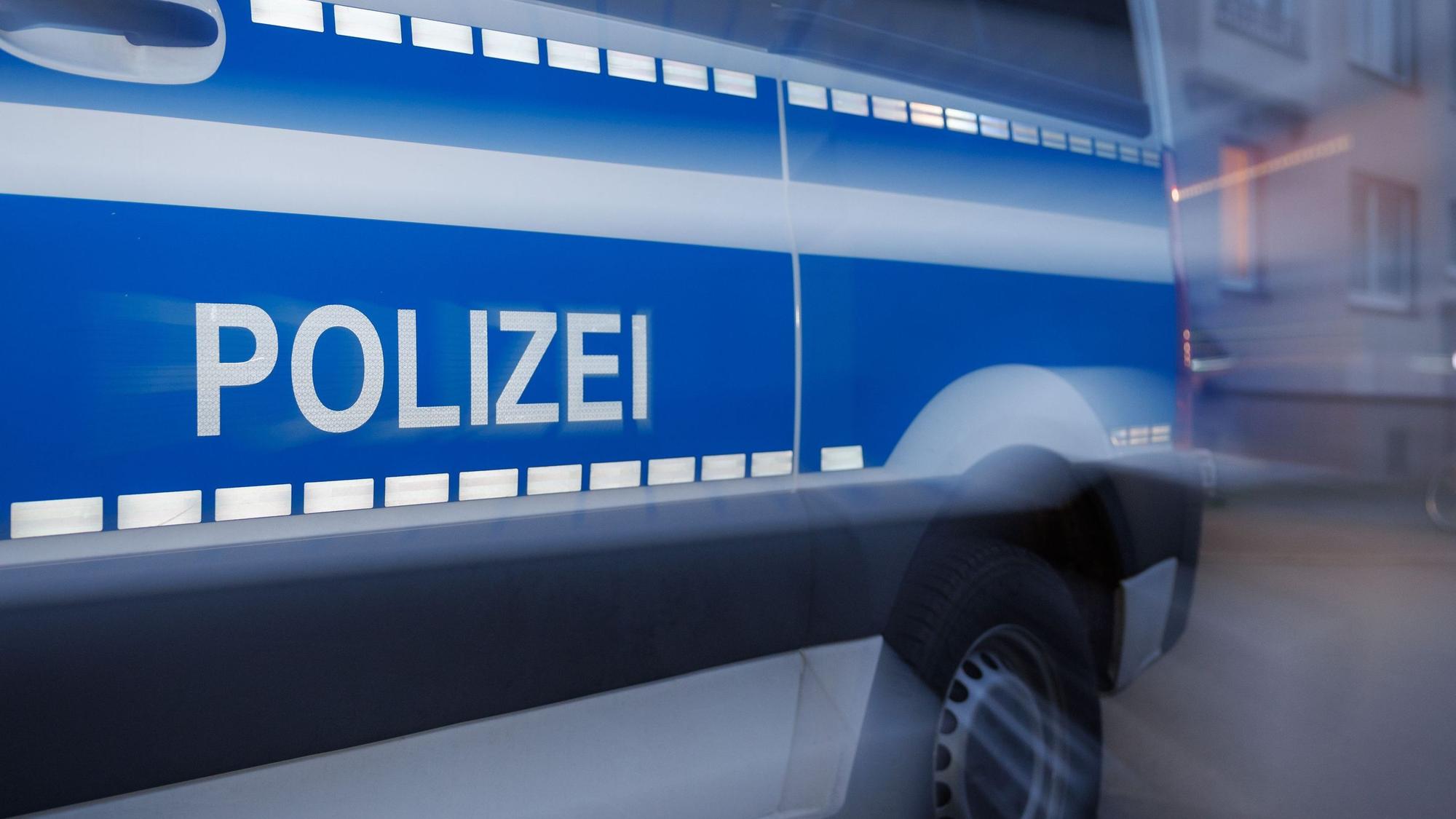 Das Symbolbild zeigt ein Polizeifahrzeug im Dämmerlicht.