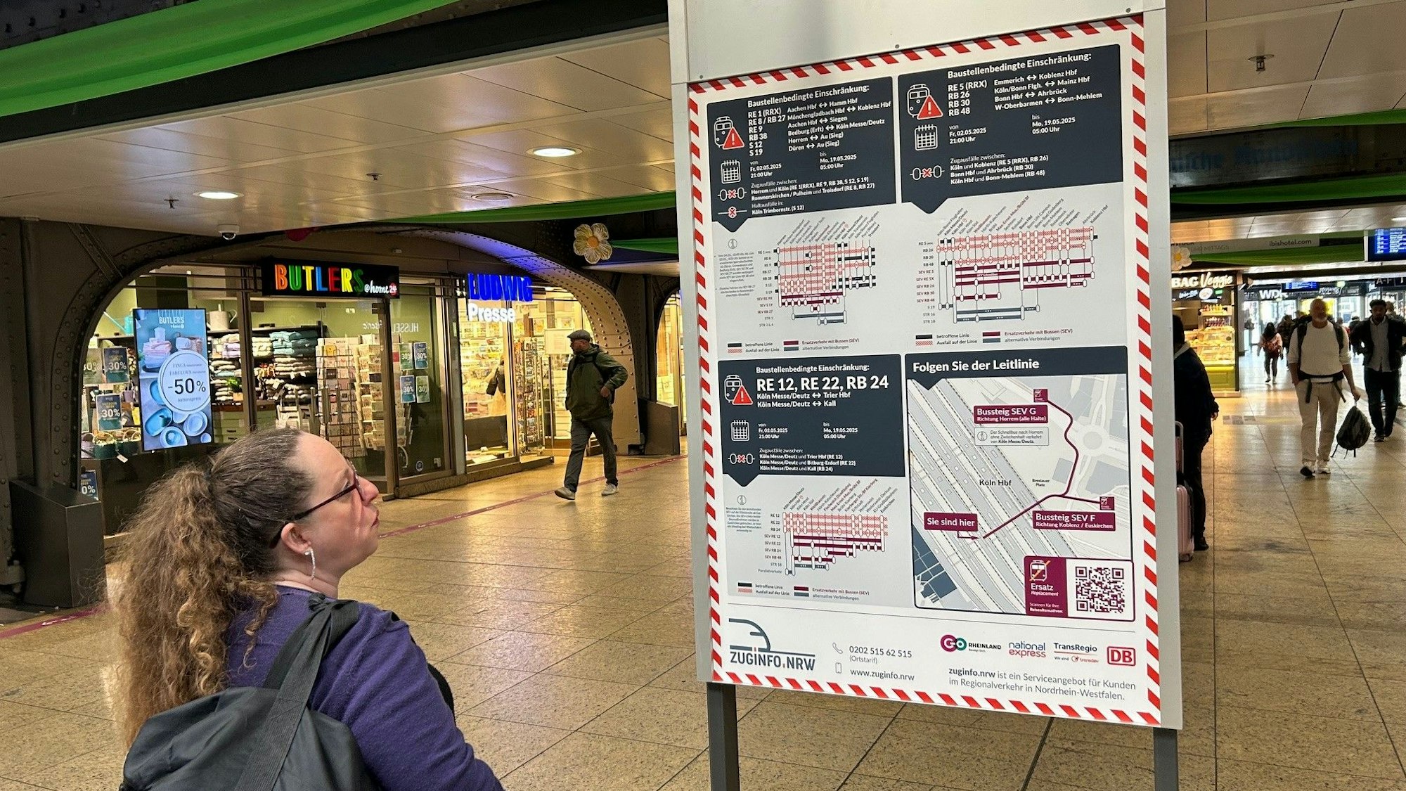 Welcher Zug fällt aus? Eine Frau studiert die Baustellenpläne der Bahn in der Passage des Kölner Hauptbahnhofs.