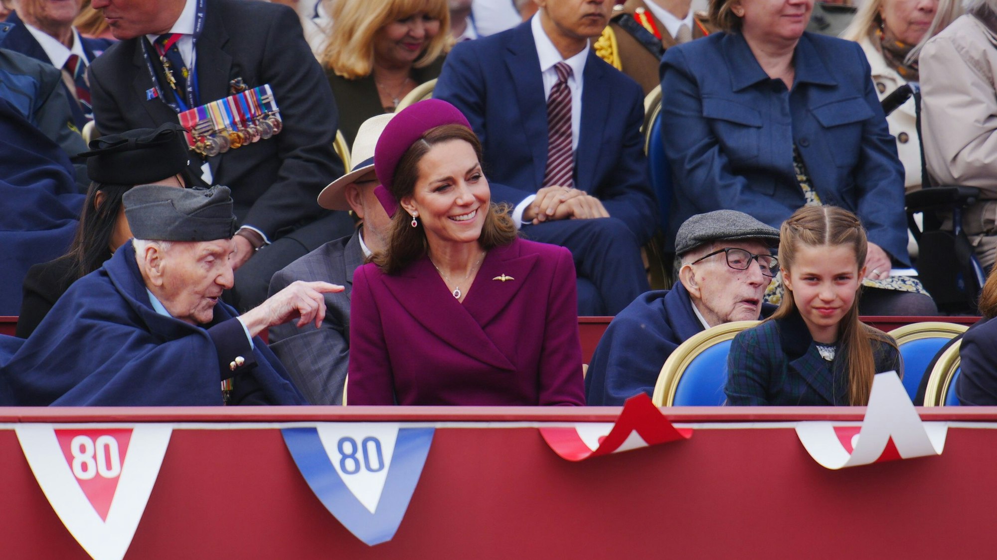 Der Veteran Bernard Morgan (l-r), Kate, Prinzessin von Wales, und ihre Tochter Prinzessin Charlotte beobachten die Militärprozession anlässlich des 80. Jahrestages des Victory Europe Day.