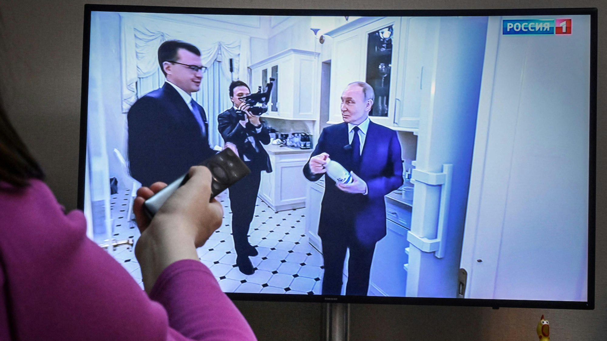Eine Frau schaut die neue Dokumentation über Wladimir Putin. Der Kremlchef ist dort zusammen mit Reporter Pawel Zarubin in der Küche seiner Wohnung im Kreml zu sehen.
