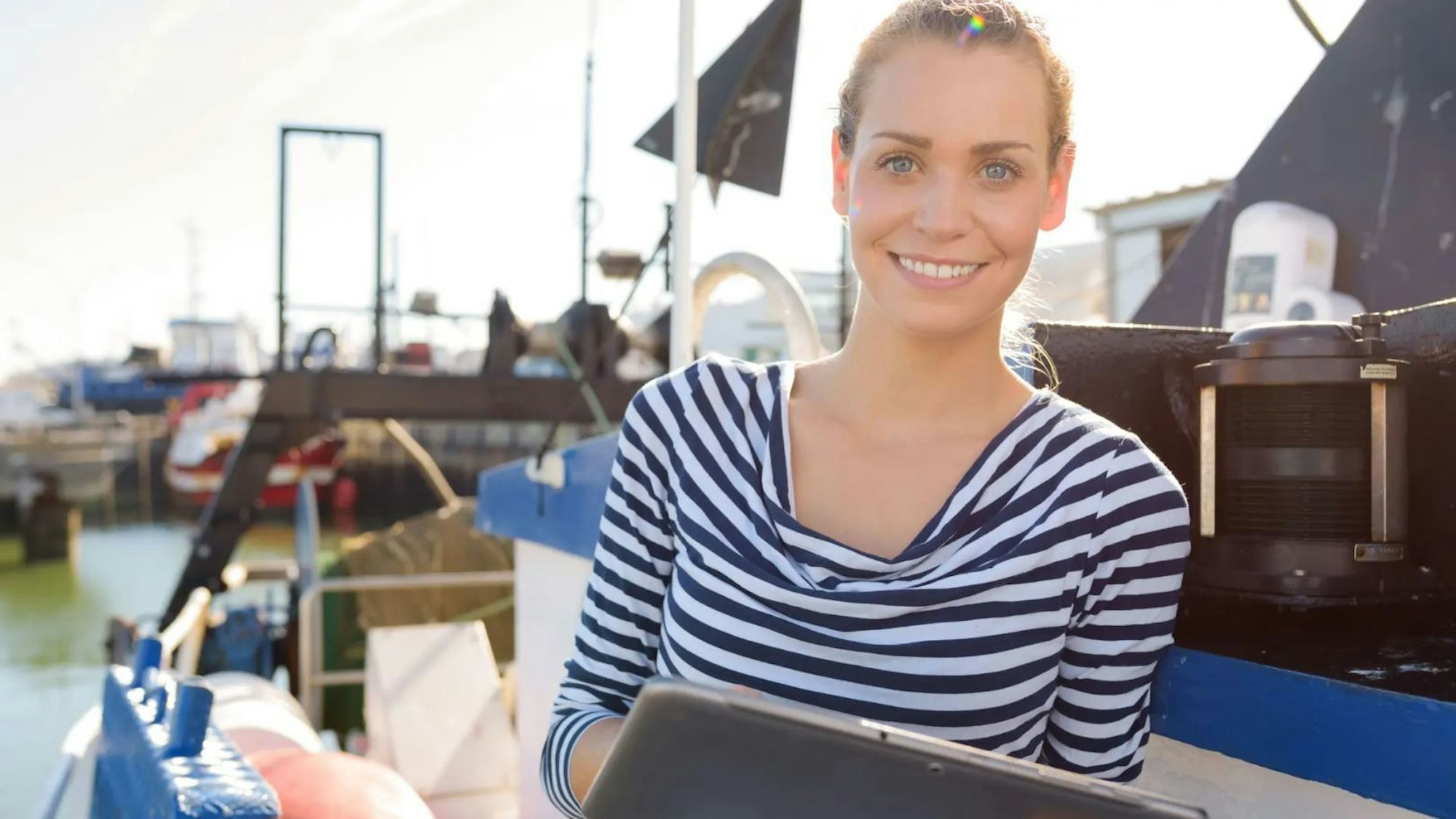 Frau mit Tablet auf einem Schiff.