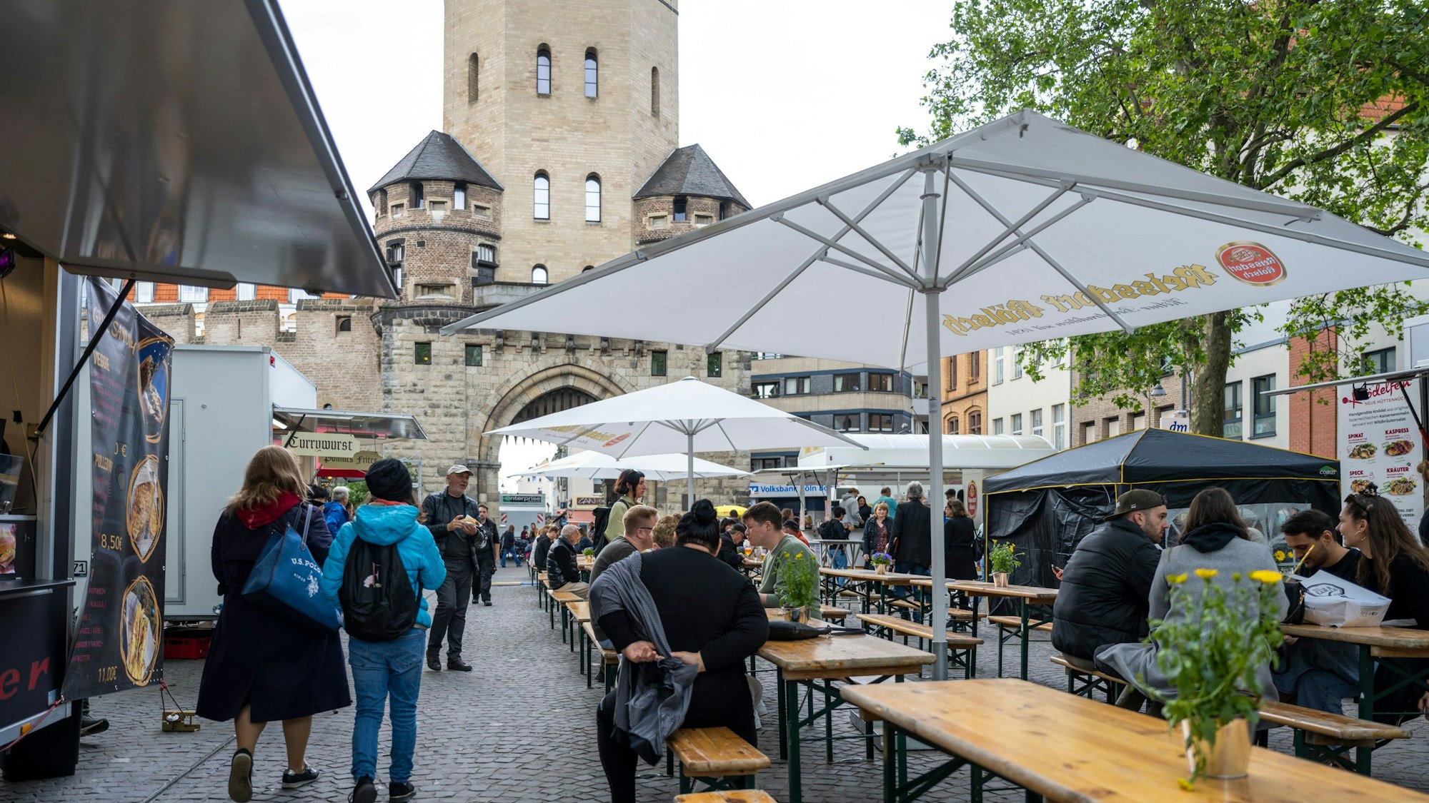 Der Feierabendmarkt auf dem Chlodwigplatz mit Bierbänken- und tischen, drumherum sind Foodtrucks und Getränkestände. (Archivbild 2024)