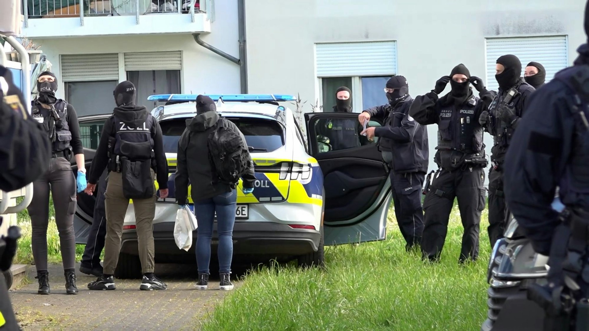 Einsatzkräfte der Polizei und Spezialeinheiten bereiten sich für eine Durchsuchung vor.