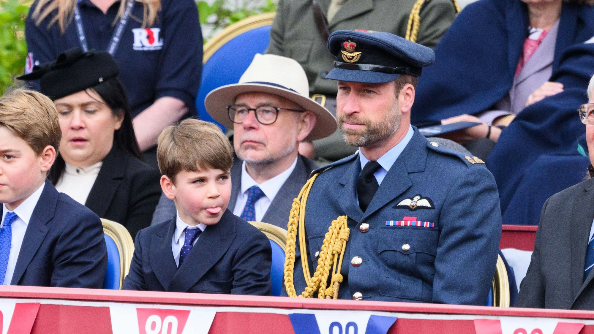 Zunge raus: Während sich Bruder George und Vater William ganz dem Protokoll widmen, sorgt Prinz Louis mit einem frechen Moment für Auflockerung bei den Feierlichkeiten zum 80. VE Day.