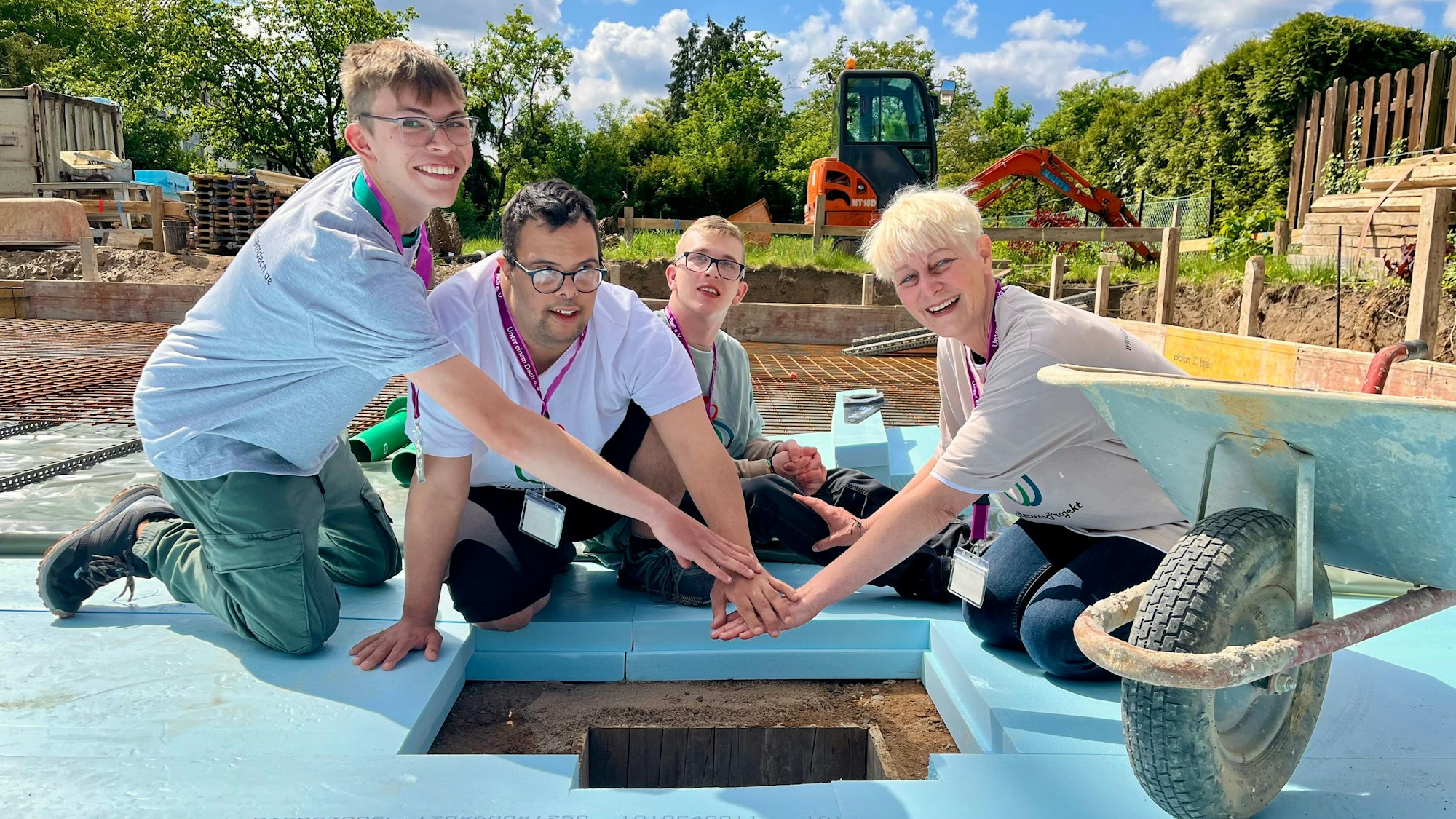 Vier Menschen bei einer Grundsteinlegung