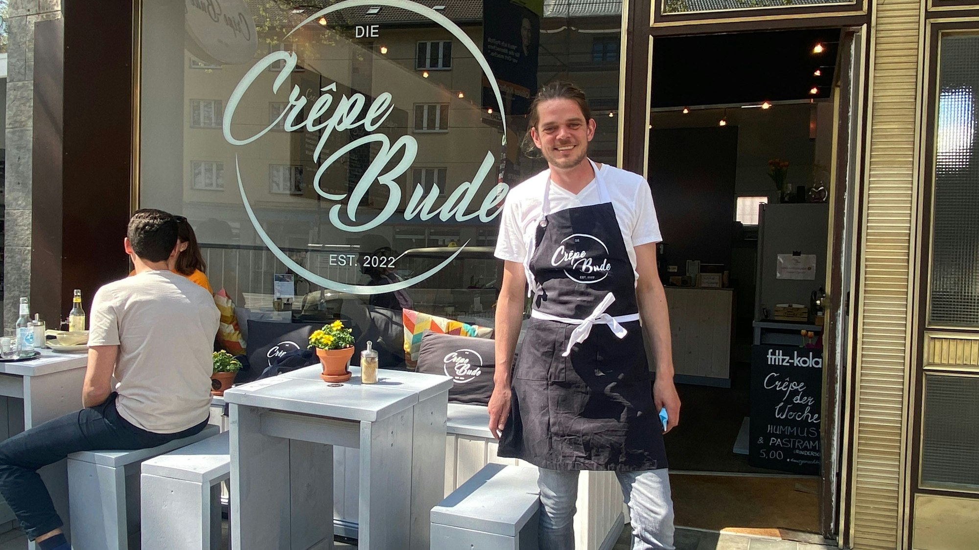 Niklas Lütkemeyer steht am Höninger Weg vor dem Eingang seiner Crêpe-Bude.