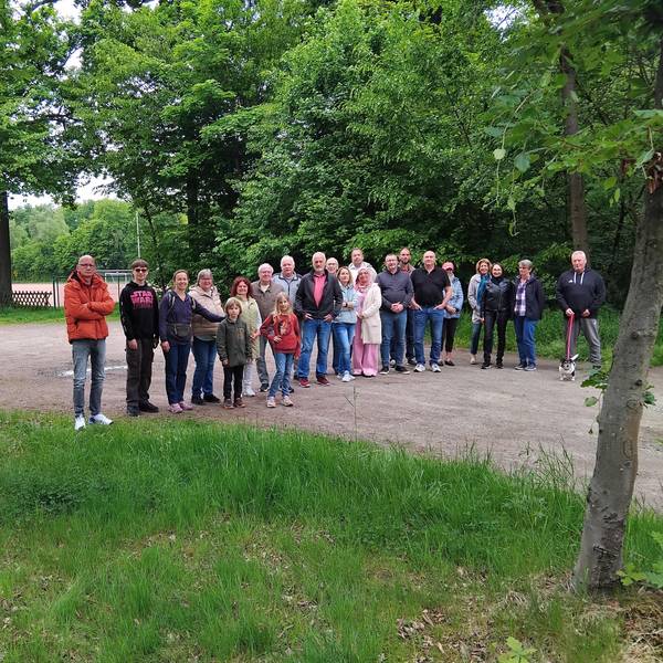 Menschen stehen auf dem Parkplatz eines Sportplatzes