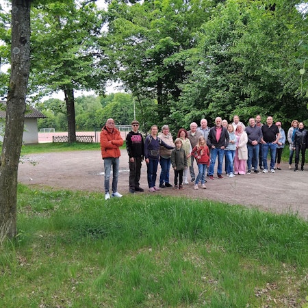 Menschen stehen auf dem Parkplatz eines Sportplatzes