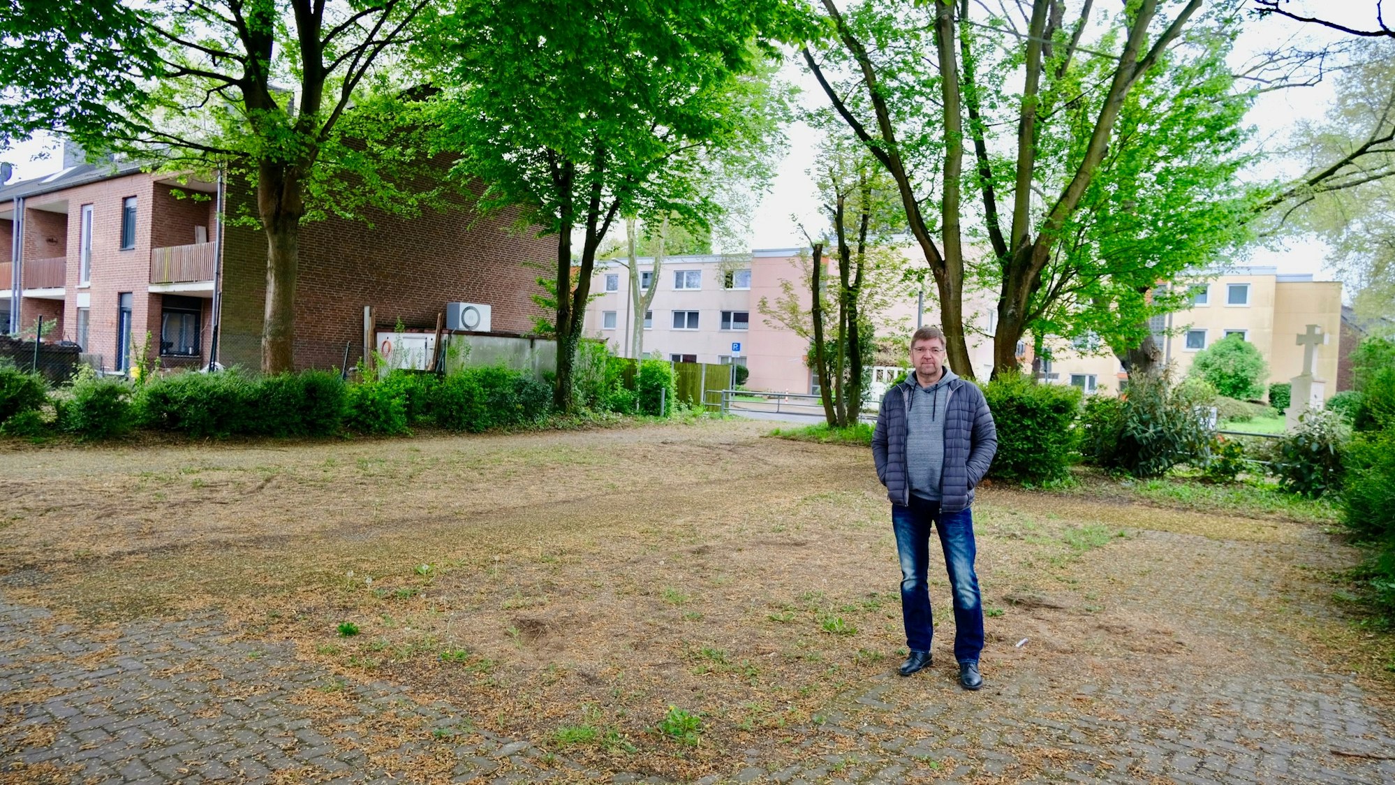 Ein Mann steht auf einem leeren Spielplatz an der Ostlandstraße, Ecke Schulstraße.