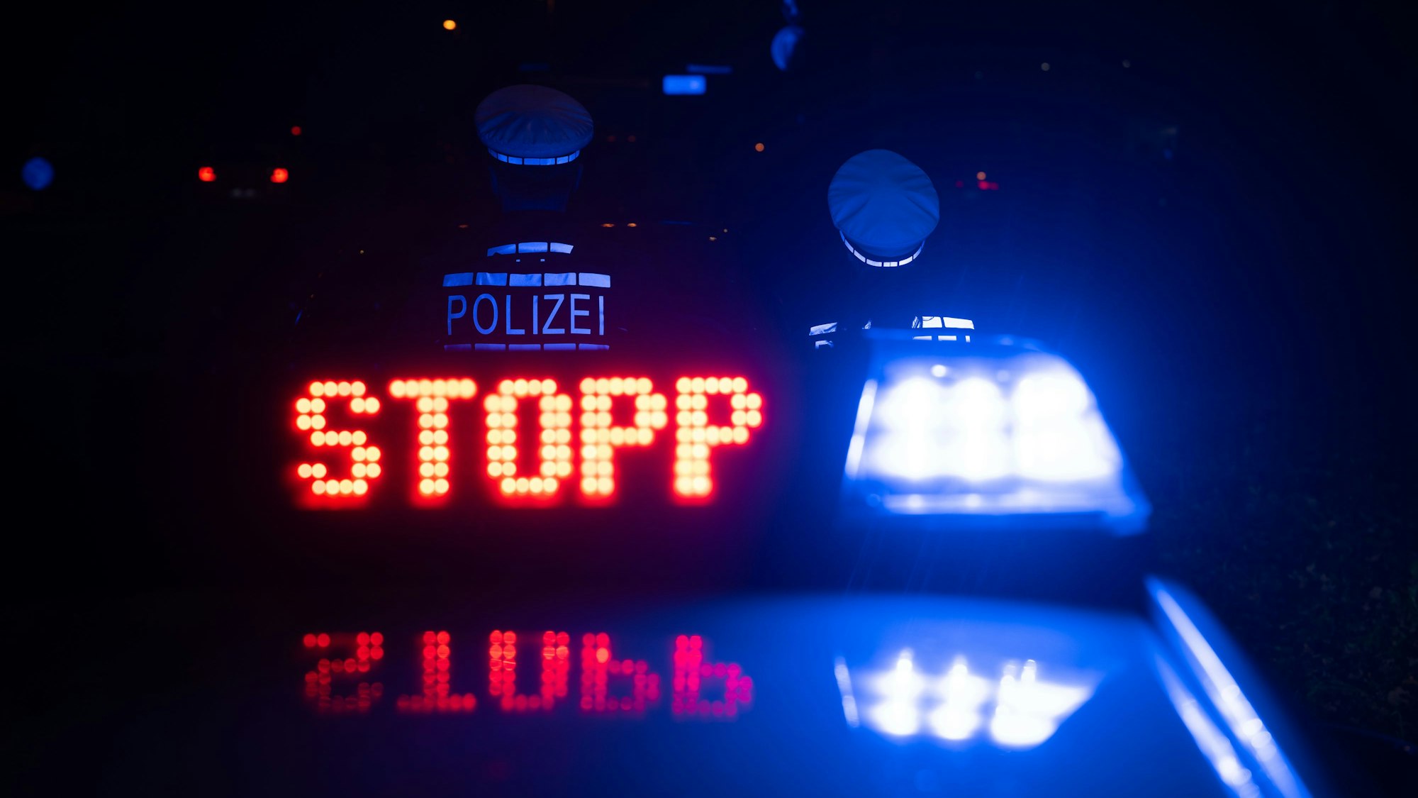 Das Wort Stopp ist auf dem Dach eines Polizeiwagens zu lesen.
