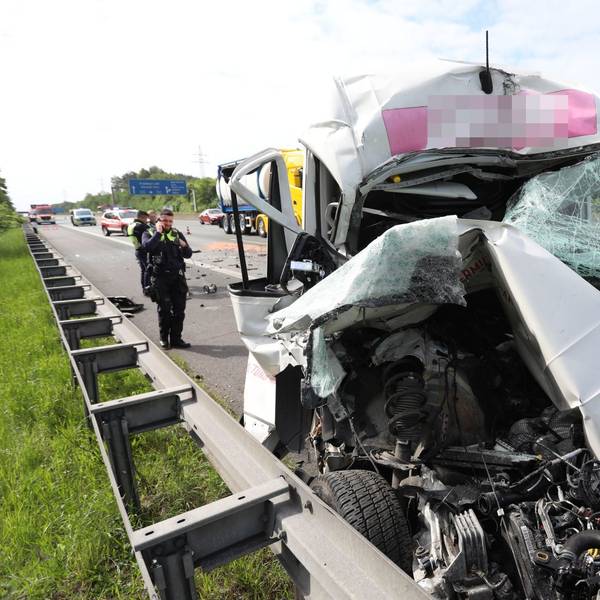 Ein stark zerstörtes Fahrzeug auf dem Standstreifen einer Autobahn.