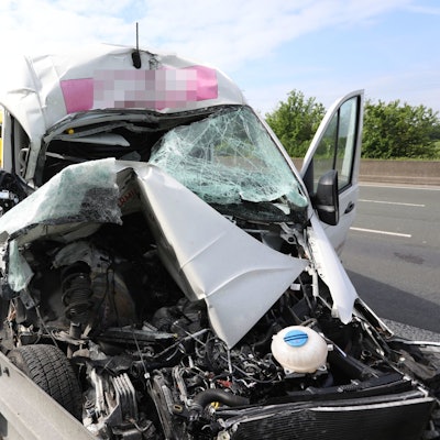 Ein stark zerstörtes Fahrzeug auf dem Standstreifen einer Autobahn.