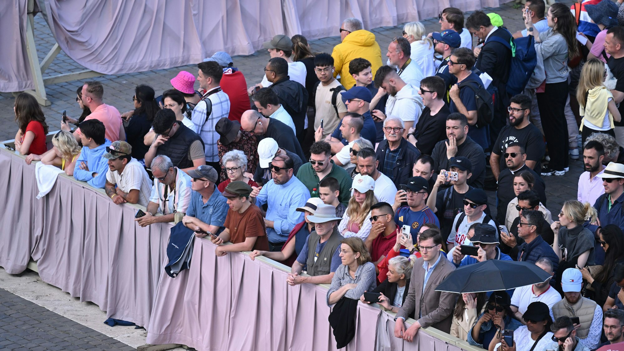 Menschen stehen kurz vor Beginn des Konklave zur Wahl eines neuen Papstes auf dem Petersplatz.